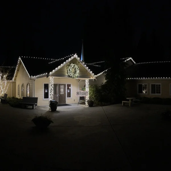 Commercial building illuminated with festive white lights professionally installed by our exterior maintenance service.