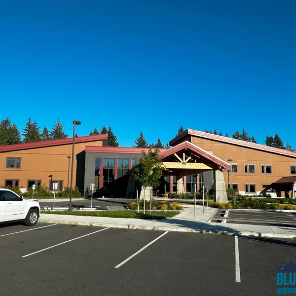 Exterior view of a commercial building after professional roof cleaning and window cleaning service; white GMC Yukon is