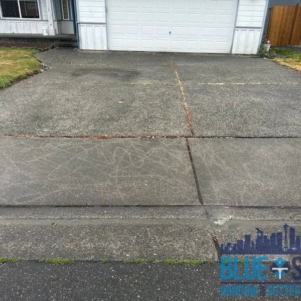 Dirty concrete driveway shows dark stains and grime before professional pressure washing.