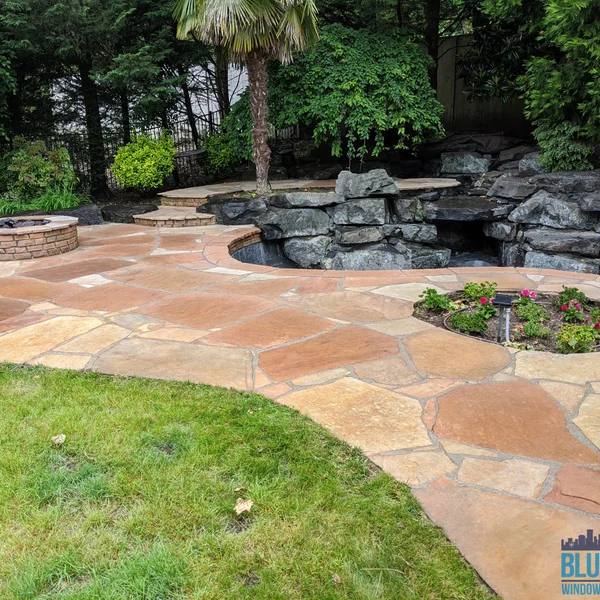 Flagstone patio is clean after professional moss and algae removal, part of residential exterior maintenance.