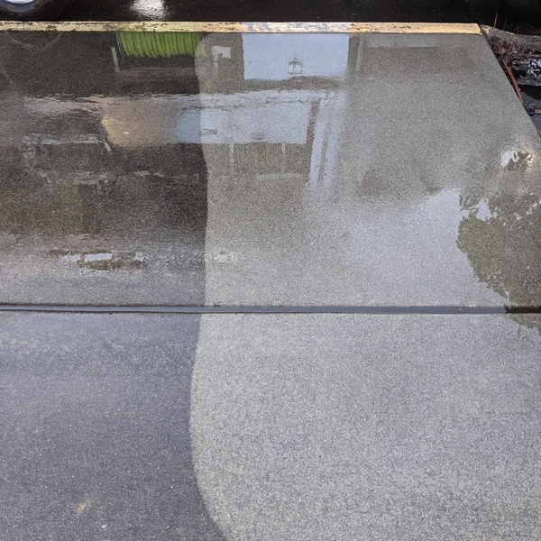 Commercial concrete surface shows dramatic cleaning results after professional pressure washing service.