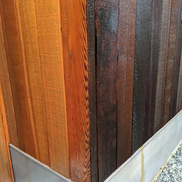 Cedar siding showcases before and after soft wash treatment for moss and algae removal on a house.