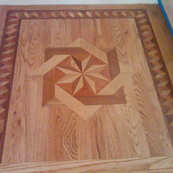 Custom hardwood flooring features a starburst pattern surrounded by geometric border detail.