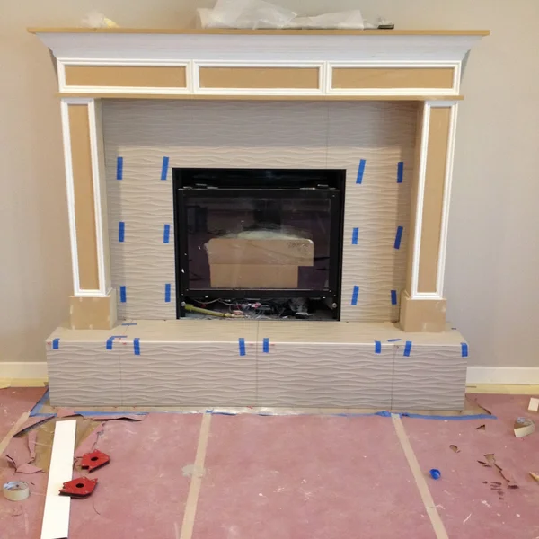 New tiled fireplace in progress with a white mantel is being installed in this Seattle home renovation project.