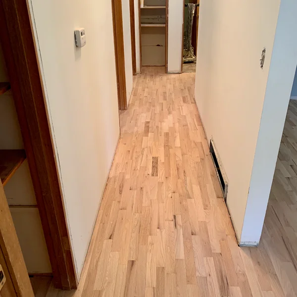 Newly installed light hardwood flooring runs through a home hallway during a Greater Seattle renovation project.