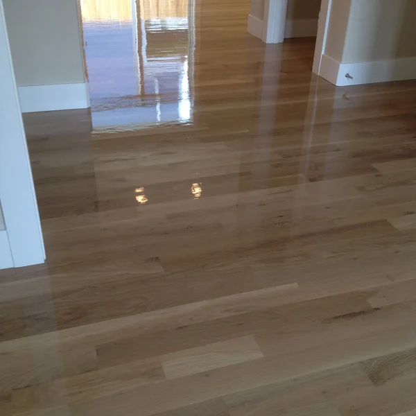 Newly refinished light hardwood flooring shines in this Seattle home renovation project.