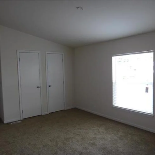 This bedroom within our manufactured home design offers ample space and storage with a built-in closet and natural light.