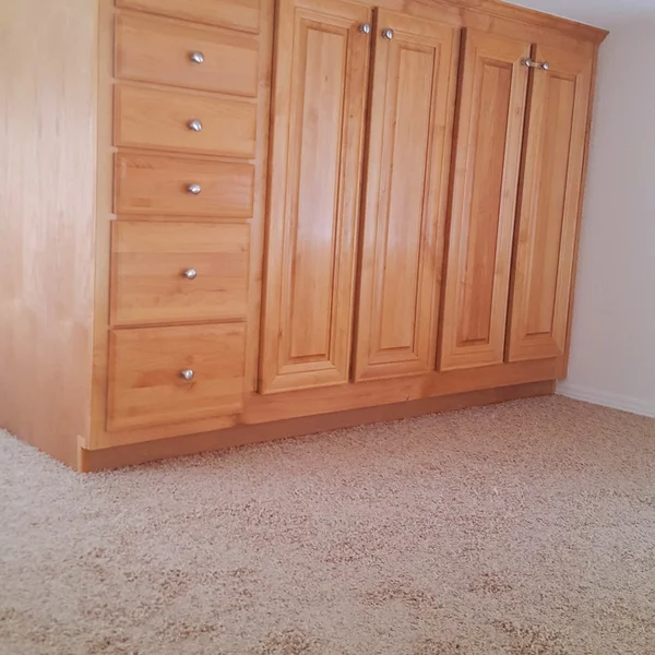 Built-in light wood cabinetry with silver hardware is showcased in this manufactured home ADU interior.