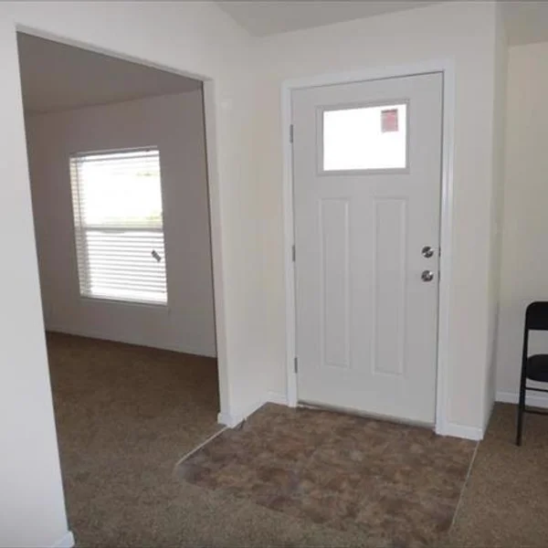 The welcoming entryway of this manufactured home features neutral colors, ensuring a seamless transition to other areas in this accessory dwelling unit.