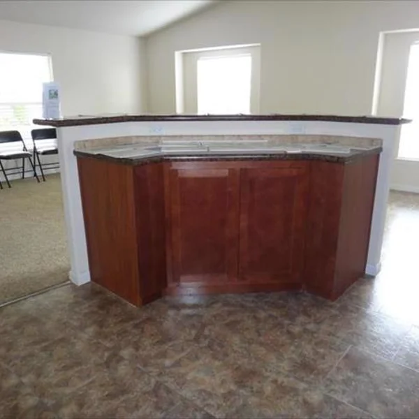 This spacious model features a large mahogany kitchen island with a marble countertop, perfect for entertaining guests or preparing family meals.