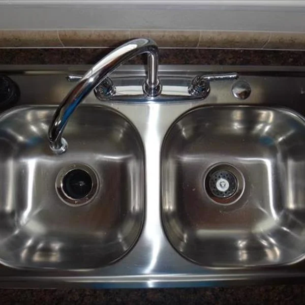 Efficient kitchen design: A stainless steel double sink maximizes space in this ADU, tiny home, or manufactured home.