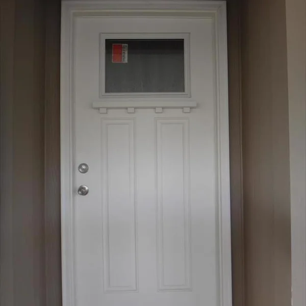 A stylish white door enhances the curb appeal of this quality-built ADU or manufactured home.