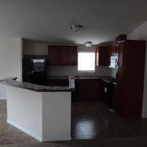 This kitchen design maximizes space with ample cabinetry and a convenient breakfast bar in a manufactured home.