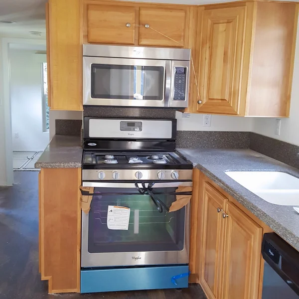 Bright ADU kitchen featuring a Whirlpool stainless steel oven and microwave combo, plus light wood cabinetry.