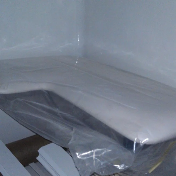 A new mattress wrapped in plastic sits inside a manufactured home ready for installation.