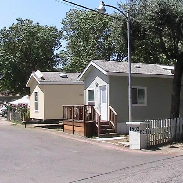 Two park model homes for student housing with decks and light exteriors.