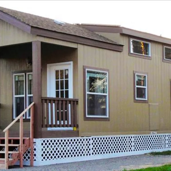 This charming park model offers comfortable living with a cozy front porch and classic design elements.